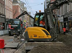 Mini excavator digging a trench during street reconstruction work