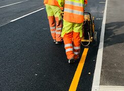 Road marking crew painting a yellow centre line on a new carriageway